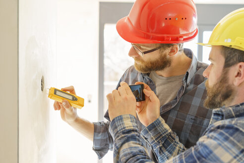 Zwei Handwerker mit Messgerät auf der Baustelle - LAF001597