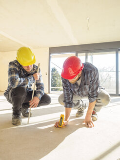 Zwei Handwerker mit Messgerät auf der Baustelle - LAF001598