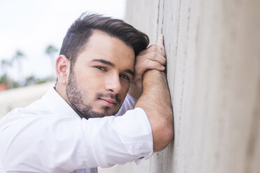 Portrait of young businessman leaning against wall - SIPF000076