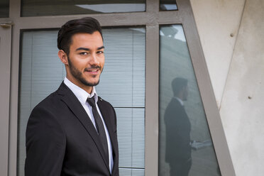 Portrait of smiling businessman wearing black suit - SIPF000083