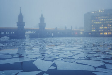 Germany, Berlin, view to Oberbaum Bridge with driving underground train at fog in winter - ASCF000465