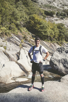 Spanien, A Capela, Porträt eines lächelnden, auf einem Felsen stehenden Langläufers - RAEF000784