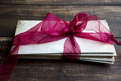 Stack of old love letters tied with red ribbon - SARF002457