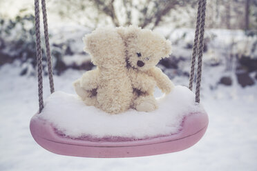 Zwei sich umklammernde Teddybären auf einer schneebedeckten Schaukel - SARF002459
