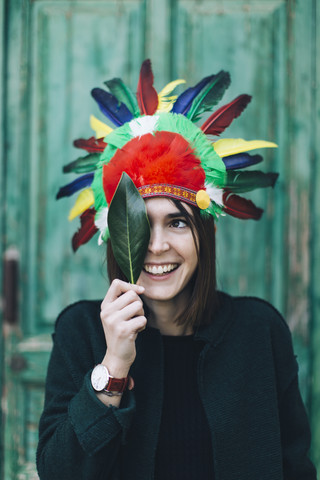 Portrait of woman wearing Indian headdress covering one eye with a leaf stock photo