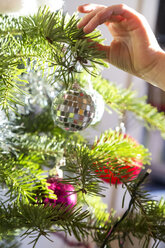 Hand of girl decorating Christmas tree - SARF002464