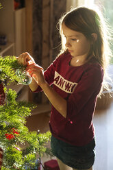Girl decorating Christmas tree - SARF002465
