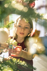 Porträt eines Mädchens beim Schmücken des Weihnachtsbaums - SARF002467