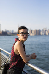 USA, New York City, Williamsburg, Porträt einer jungen Frau, die sich an ein Geländer lehnt - GIOF000690