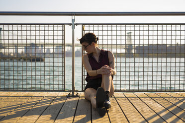 USA, New York City, Williamsburg, young woman leaning against railing - GIOF000701