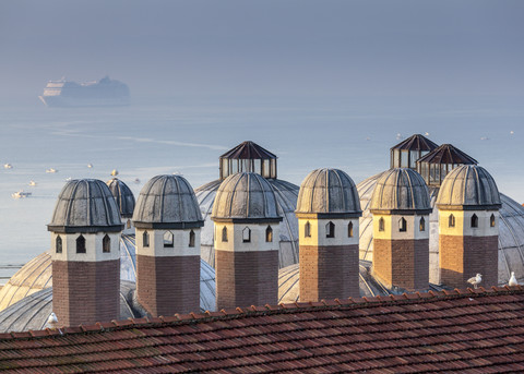 Türkei, Istanbul, Blick auf traditionelle Dächer und Kreuzfahrtschiffe auf dem Bosporus im Hintergrund, lizenzfreies Stockfoto