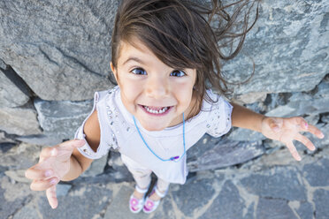 Porträt eines starren kleinen Mädchens mit wehendem Haar vor einer Felswand - SIPF000105