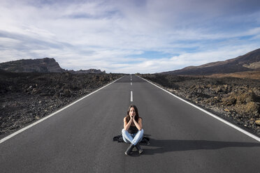 Spain, Tenerife, woman with closed eyes sitting on an empty road - SIPF000113