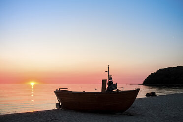 Deutschland, Rügen, Binz, Strand mit Fischerboot bei Sonnenuntergang - PUF000460