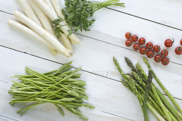 Weißer, grüner und wilder Spargel, Petersilie und Kirschtomaten auf Holz - ASF005807