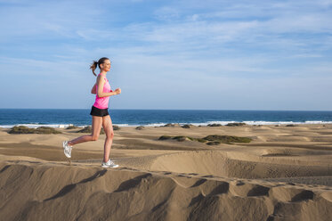 Junge Frau joggt am Strand - DIGF000001