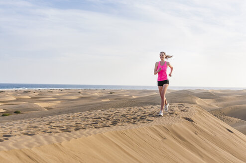 Junge Frau joggt am Strand - DIGF000003