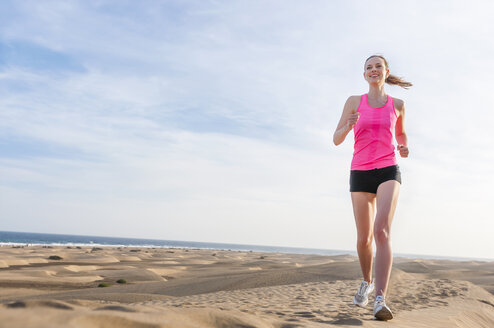 Junge Frau joggt am Strand - DIGF000004