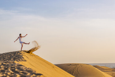 Woman on dune kicking sand - DIGF000018
