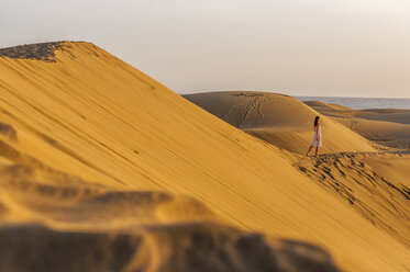Woman walking over sand dunes - DIGF000020