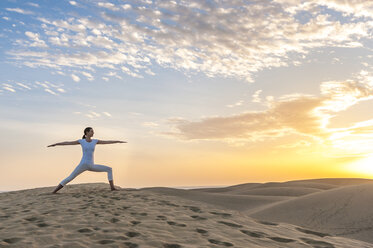 Woman practising yoga on sand dunes - DIGF000025