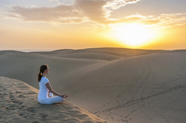 Woman practising yoga on sand dunes - DIGF000026