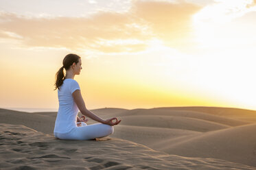 Woman practising yoga on sand dunes - DIGF000027