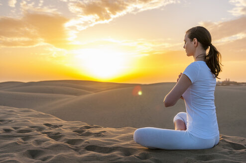 Woman practising yoga on sand dunes - DIGF000028