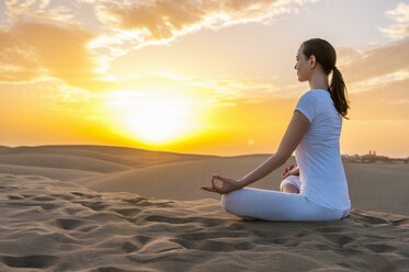 Woman practising yoga on sand dunes - DIGF000029