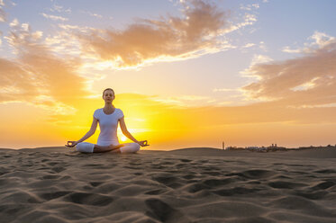 Woman practising yoga on sand dunes - DIGF000030