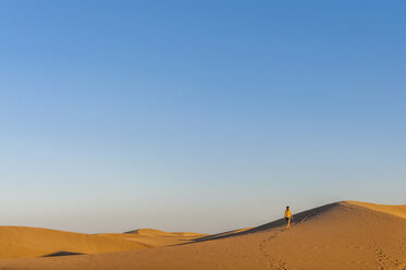 Woman walking over sand dunes - DIGF000032