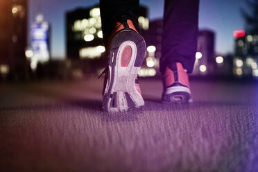 Sneakers of jogging man on tarmac at night - RBF004069
