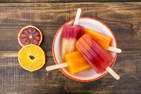 Bowl of different homemade orange ice lollies - SARF002478