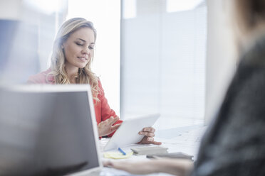 Frau im Büro schaut auf eine digitale Tafel - ZEF007976