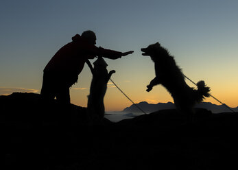 Grönland, Kulusuk, Mann kümmert sich um Hunde - ALRF000352