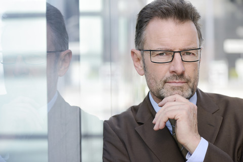 Porträt eines Geschäftsmannes mit Hand am Kinn, lizenzfreies Stockfoto