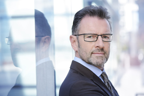 Porträt eines Geschäftsmannes mit Brille und Bartstoppeln, lizenzfreies Stockfoto