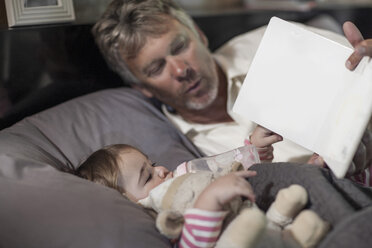 Mann liest Buch mit kleinem Mädchen - ZEF008093