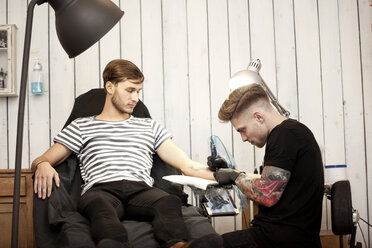 Tattooist at work in his tattoo studio - MFRF000491