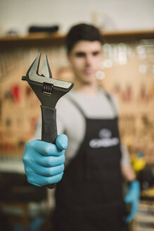 Junger Mechaniker bei der Arbeit in einer Reparaturwerkstatt - RAEF000788