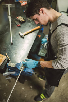 Junger Mechaniker bei der Arbeit in einer Reparaturwerkstatt - RAEF000794