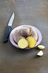 Bowl of organic potatoes with purple peel - MYF001314