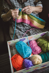 Box of different balls of wool and knitting senior woman - RAEF000806