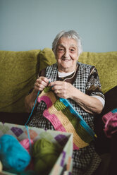 Portrait of smiling senior woman with knitting - RAEF000811