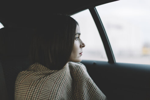 Frau sitzt im Auto und schaut durch das Fenster - JPF000106