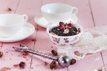 Schale mit schwarzem Tee und getrockneten Rosenblüten - SBDF002660