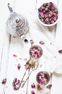 Teekanne und zwei Gläser mit Rosenblütentee mit getrockneten Rosenblüten - SBDF002662