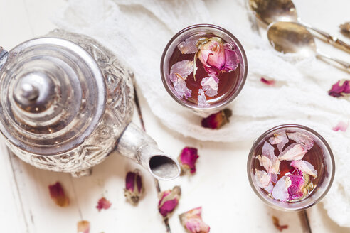 Teekanne und zwei Gläser mit Rosenblütentee mit getrockneten Rosenblüten - SBDF002664