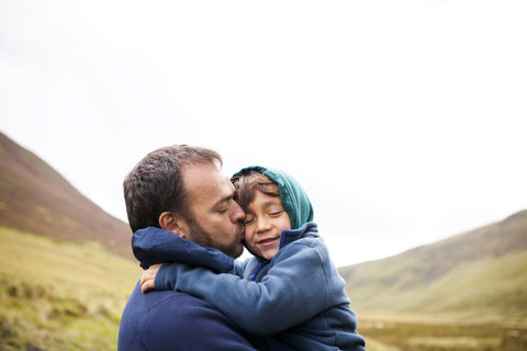 UK, Bala, Vater und Sohn umarmen sich, lizenzfreies Stockfoto