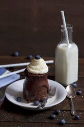 Schokoladenkuchen im Glas mit Schlagsahne, Rohrzucker und Blaubeeren und einer Flasche Milch - YFF000521